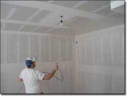Man spraying a knock down texture in New York City Home Improvement project